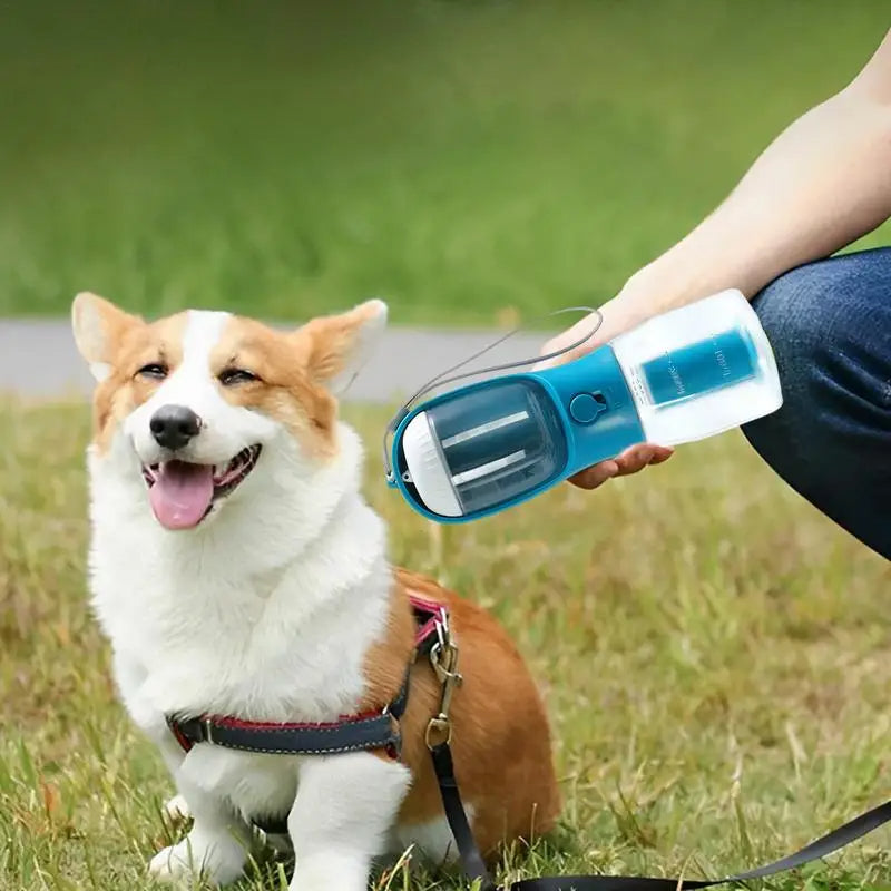 Gocrisandy dog water cup and food dispenser with garbage bag, portable multi-functional pet travel accessory in use.